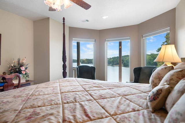 bedroom featuring access to outside, a water view, visible vents, and multiple windows