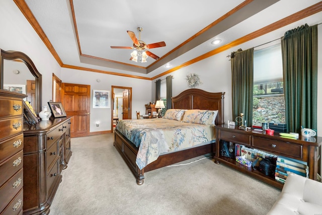 bedroom featuring ceiling fan, light colored carpet, baseboards, a raised ceiling, and crown molding