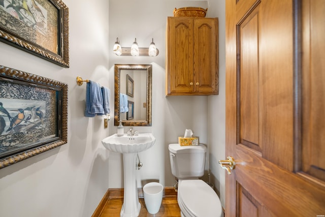 half bath with toilet and baseboards