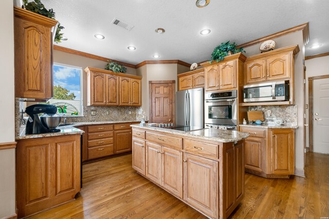 kitchen featuring light wood-style floors, visible vents, appliances with stainless steel finishes, and a center island