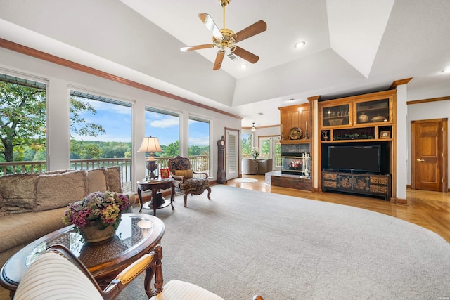 living room with recessed lighting, light wood-style floors, a ceiling fan, vaulted ceiling, and a lit fireplace