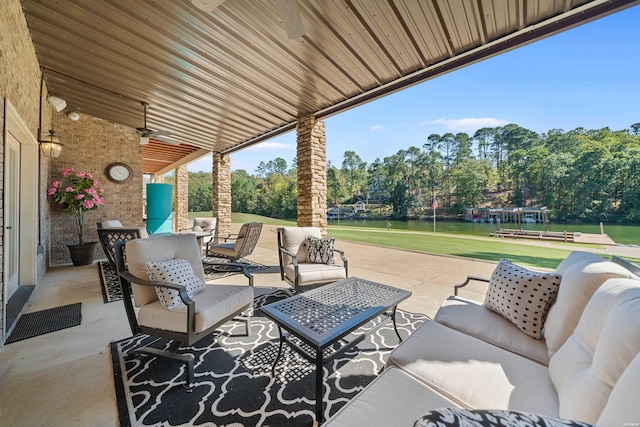 view of patio / terrace featuring a ceiling fan, outdoor dining area, a water view, and an outdoor living space