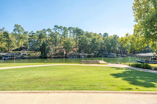 view of home's community featuring a yard, a boat dock, and a water view