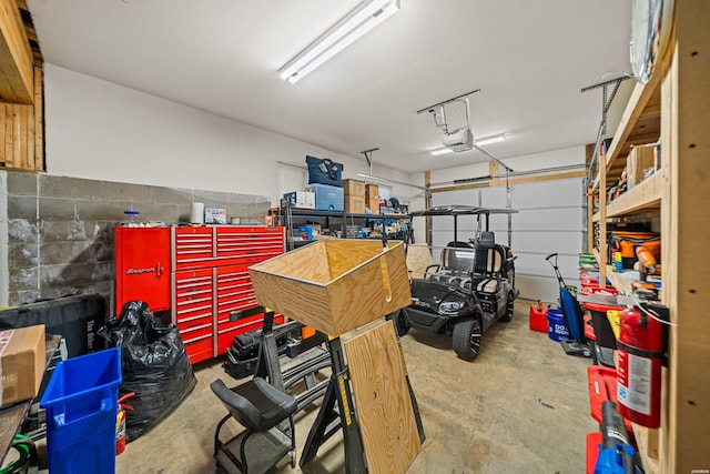 garage featuring concrete block wall and a garage door opener