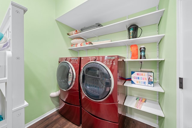 washroom featuring dark wood-type flooring, laundry area, baseboards, and washing machine and clothes dryer