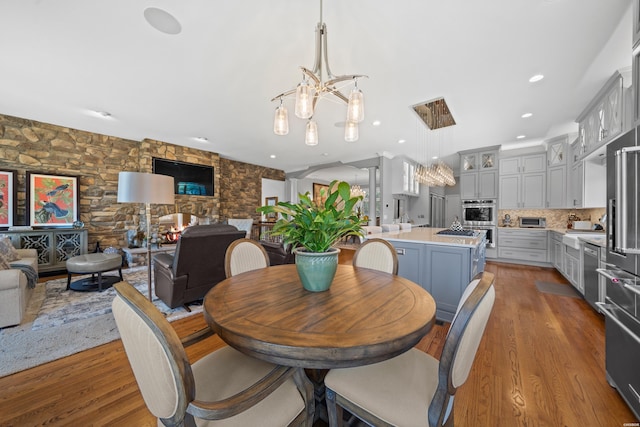 dining area featuring a toaster, light wood-style floors, recessed lighting, and an inviting chandelier