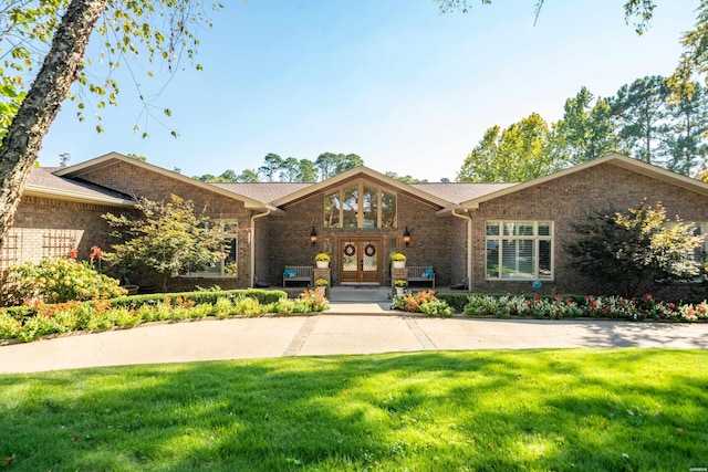 mid-century home featuring a front lawn and brick siding