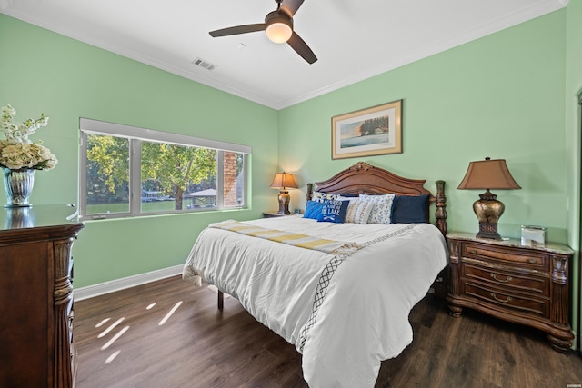 bedroom featuring crown molding, dark wood finished floors, visible vents, and baseboards