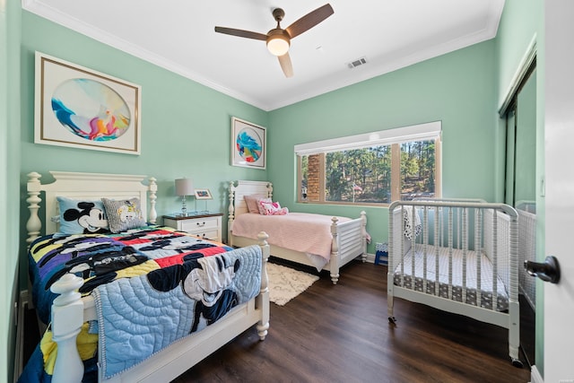 bedroom featuring crown molding, visible vents, dark wood finished floors, and a ceiling fan