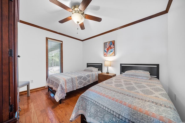 bedroom featuring a ceiling fan, wood-type flooring, baseboards, and crown molding