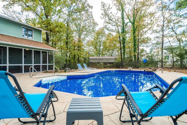 view of swimming pool featuring a sunroom, a fenced backyard, a fenced in pool, and a patio