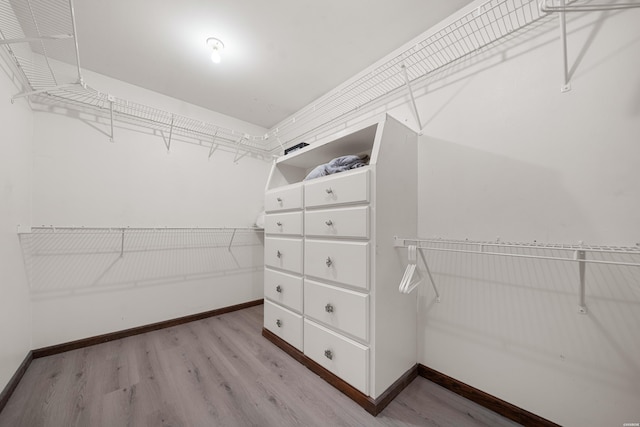 walk in closet with wood finished floors