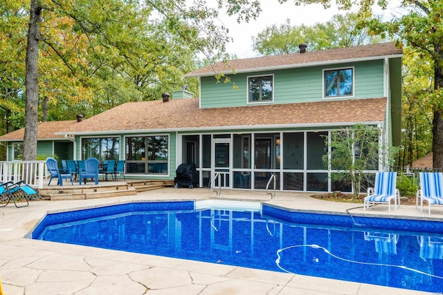 pool featuring a sunroom and a patio area