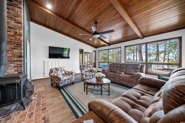 living room with wood ceiling, a wood stove, wood finished floors, high vaulted ceiling, and beamed ceiling