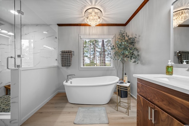 bathroom with wood finished floors, vanity, baseboards, a soaking tub, and a marble finish shower