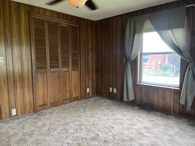 811 N 1st St, Glenwood, AR 71943 - unfurnished bedroom with light colored carpet, wood walls, a closet, and a ceiling fan