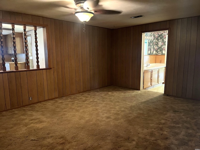811 N 1st St, Glenwood, AR 71943 - empty room featuring ceiling fan, carpet flooring, and wooden walls