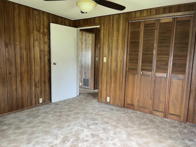 811 N 1st St, Glenwood, AR 71943 - unfurnished bedroom with carpet flooring, wood walls, a closet, and a ceiling fan