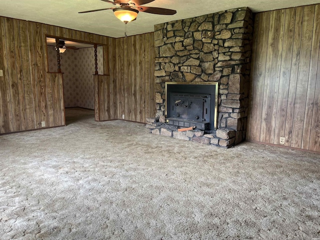811 N 1st St, Glenwood, AR 71943 - unfurnished living room with ceiling fan, carpet floors, wood walls, and a fireplace