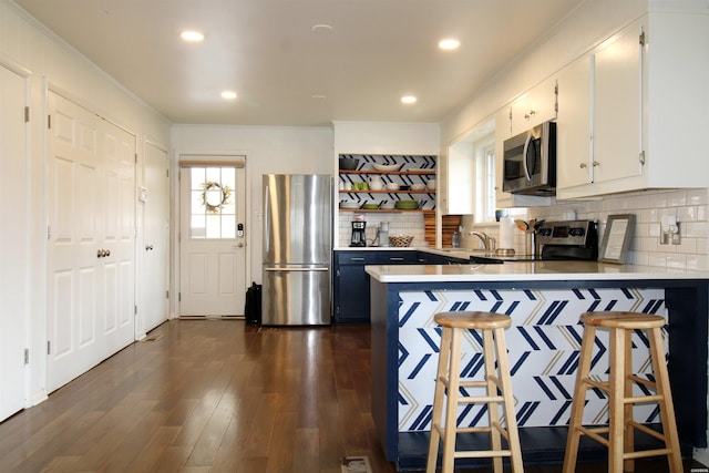 189 Bayshore Cv, Hot Springs, AR 71913 - kitchen featuring stainless steel appliances, a breakfast bar, dark wood-type flooring, white cabinets, and open shelves