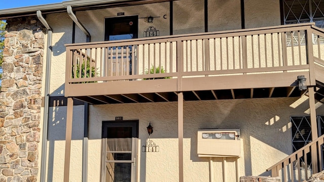 doorway to property featuring stone siding and stucco siding