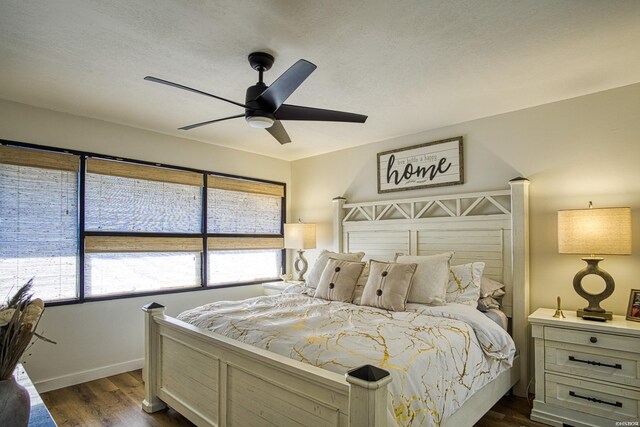 bedroom with dark wood finished floors, a ceiling fan, and baseboards