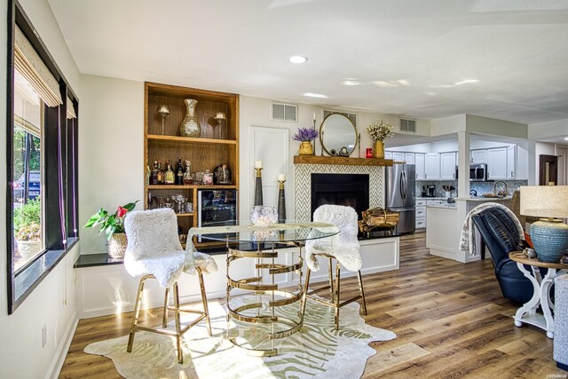 interior space with visible vents, a fireplace, and wood finished floors