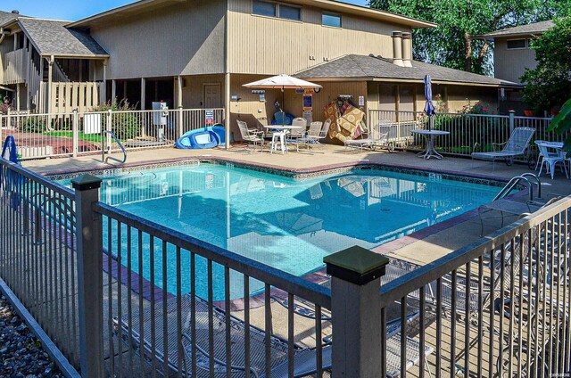 community pool featuring a patio area and fence