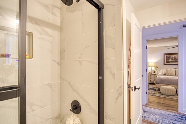 full bathroom featuring a ceiling fan, wood finished floors, connected bathroom, and an enclosed shower