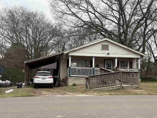 view of front of house featuring a porch, a carport, and dirt driveway