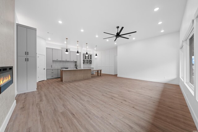 168 Krause Ln Unit B, Hot Springs, AR 71913 - unfurnished living room featuring a glass covered fireplace, ceiling fan, recessed lighting, light wood finished floors, and a sink