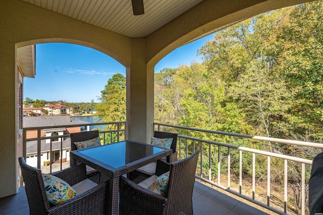 balcony with ceiling fan and a water view