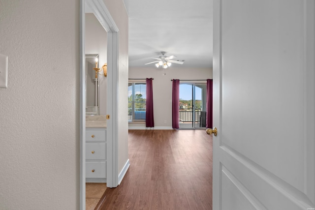 hallway featuring baseboards and wood finished floors