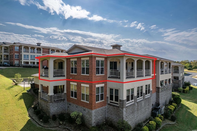 view of property exterior featuring a chimney, brick siding, and a balcony