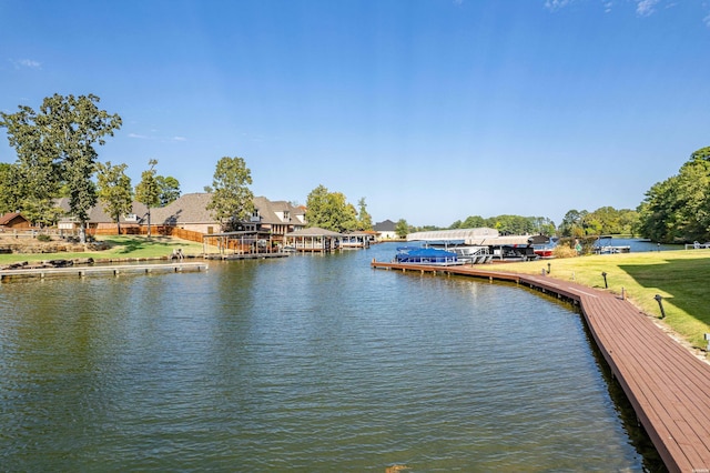 view of dock with a water view, a residential view, and a yard