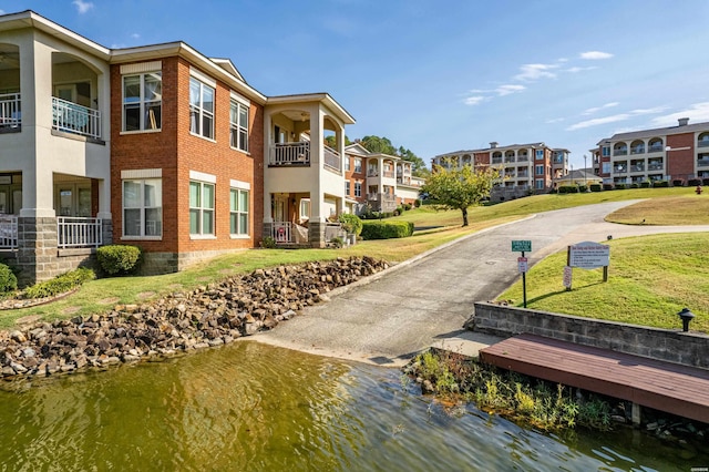 view of home's community with a water view and a yard