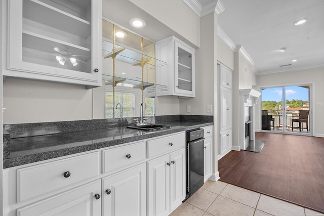 kitchen featuring glass insert cabinets, white cabinets, a sink, and ornamental molding