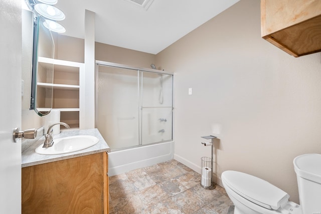 bathroom featuring toilet, vanity, shower / bath combination with glass door, and baseboards