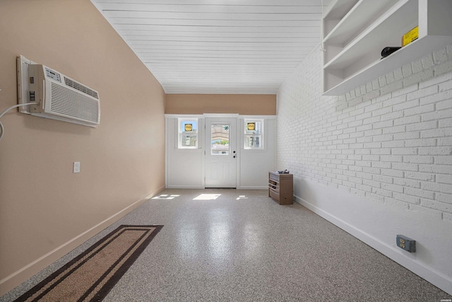 entryway with baseboards, a wall mounted air conditioner, and brick wall
