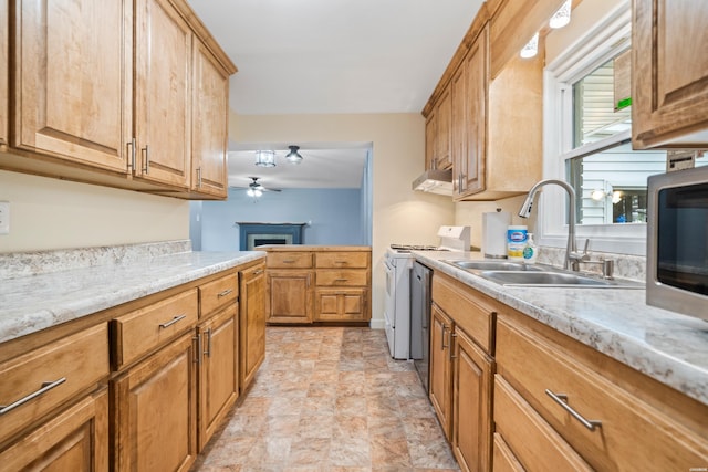 kitchen with under cabinet range hood, a fireplace, a sink, white range with gas cooktop, and light stone countertops