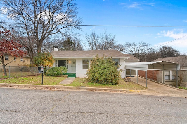 view of front of house featuring a front lawn, a chimney, fence, and a detached carport