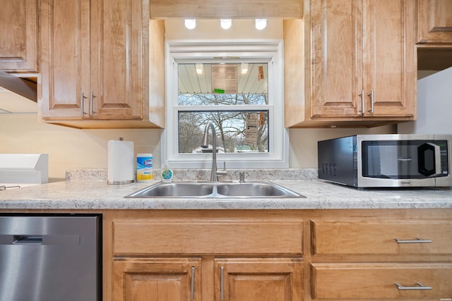 kitchen with light countertops, appliances with stainless steel finishes, and a sink