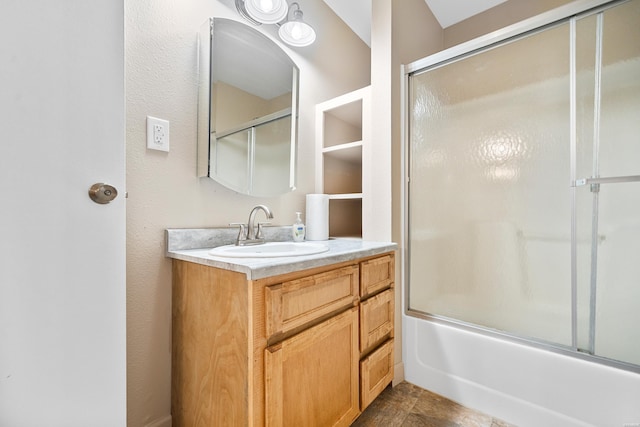 bathroom featuring bath / shower combo with glass door and vanity