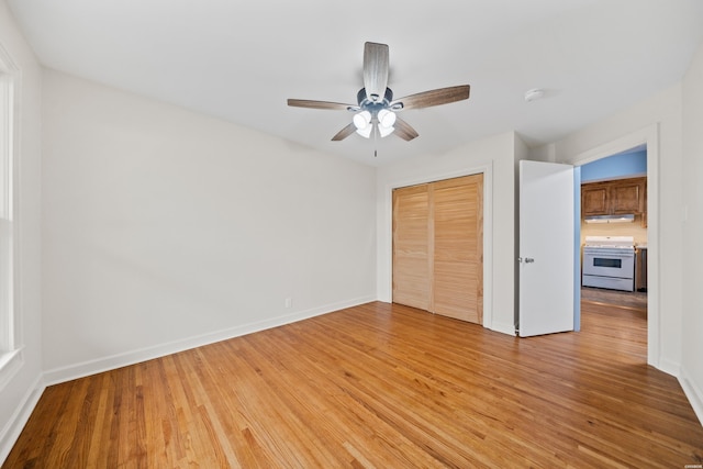 unfurnished bedroom with light wood finished floors, baseboards, and a closet