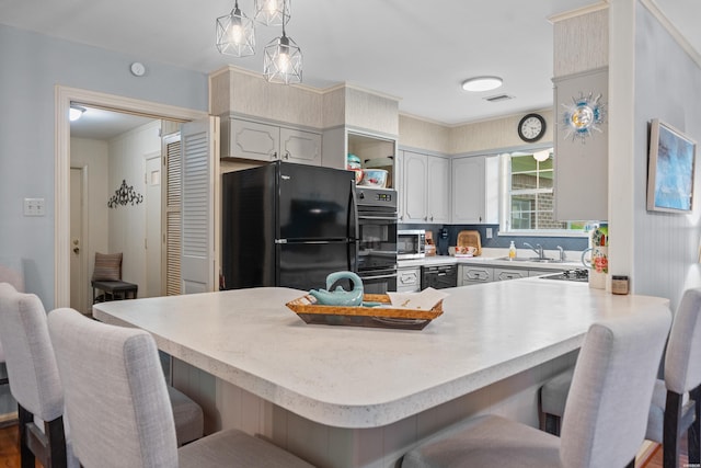206 Shawnee St, Hot Springs, AR 71901 - kitchen with black appliances, a breakfast bar, a sink, light countertops, and a peninsula