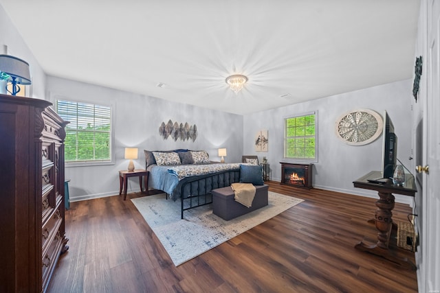 206 Shawnee St, Hot Springs, AR 71901 - bedroom featuring a warm lit fireplace, dark wood-type flooring, and baseboards