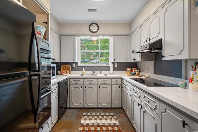 206 Shawnee St, Hot Springs, AR 71901 - kitchen with black appliances, under cabinet range hood, a sink, tasteful backsplash, and light countertops