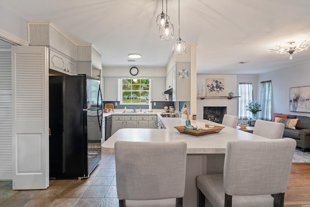 206 Shawnee St, Hot Springs, AR 71901 - kitchen with freestanding refrigerator, a peninsula, open floor plan, light countertops, and a fireplace
