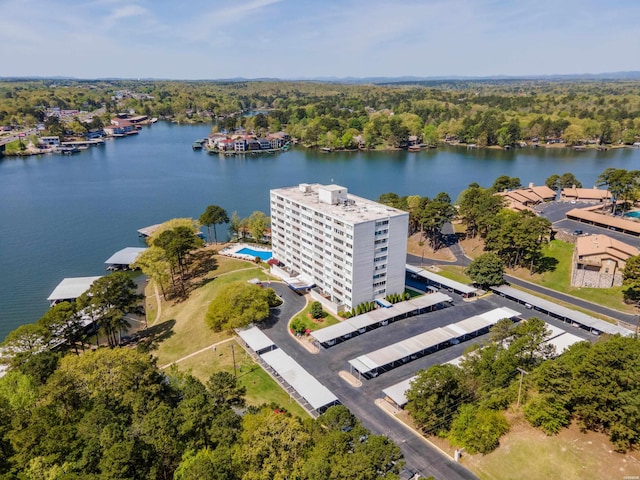 birds eye view of property featuring a water view and a wooded view