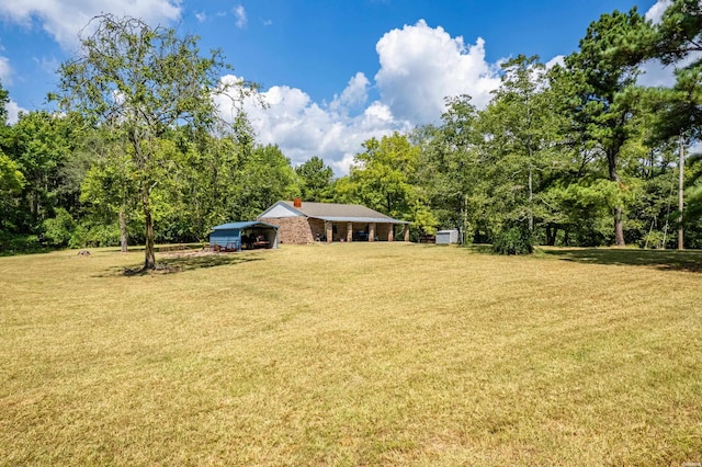 1526 Pearcy Rd, Pearcy, AR 71964 - view of grassy yard featuring a detached carport, a view of trees, and an outbuilding